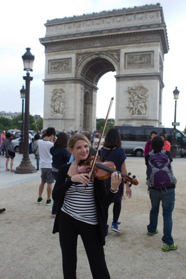 Ashley Rescot with violin at the Arc de Triomphe